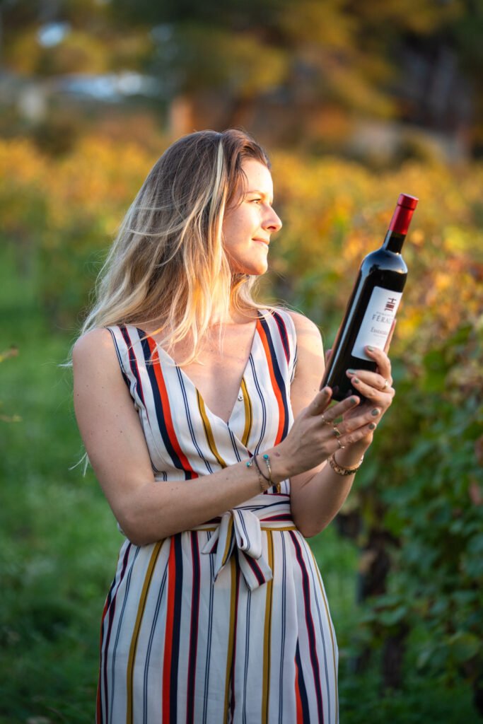 portrait de femme dans les vignes avec une bouteille de vin